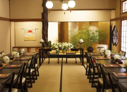 金屏風の前に前にコの字型にテーブルが並べられている和室の披露宴会場