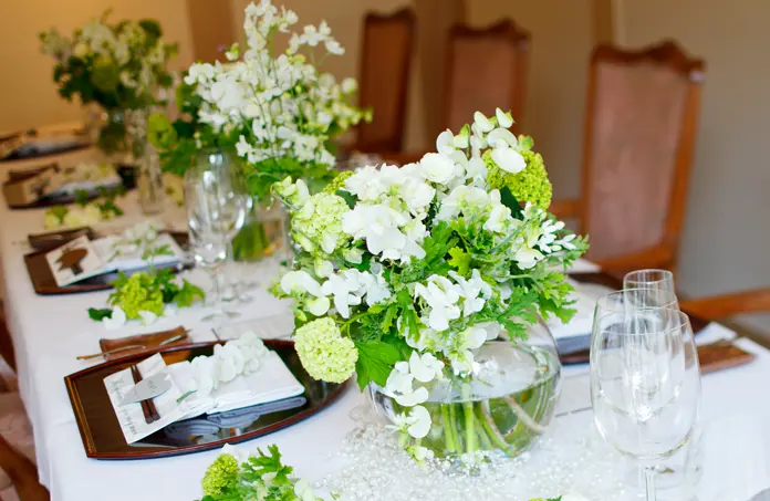 テーブルの上に花や枡が並べられている奥行きのある会場