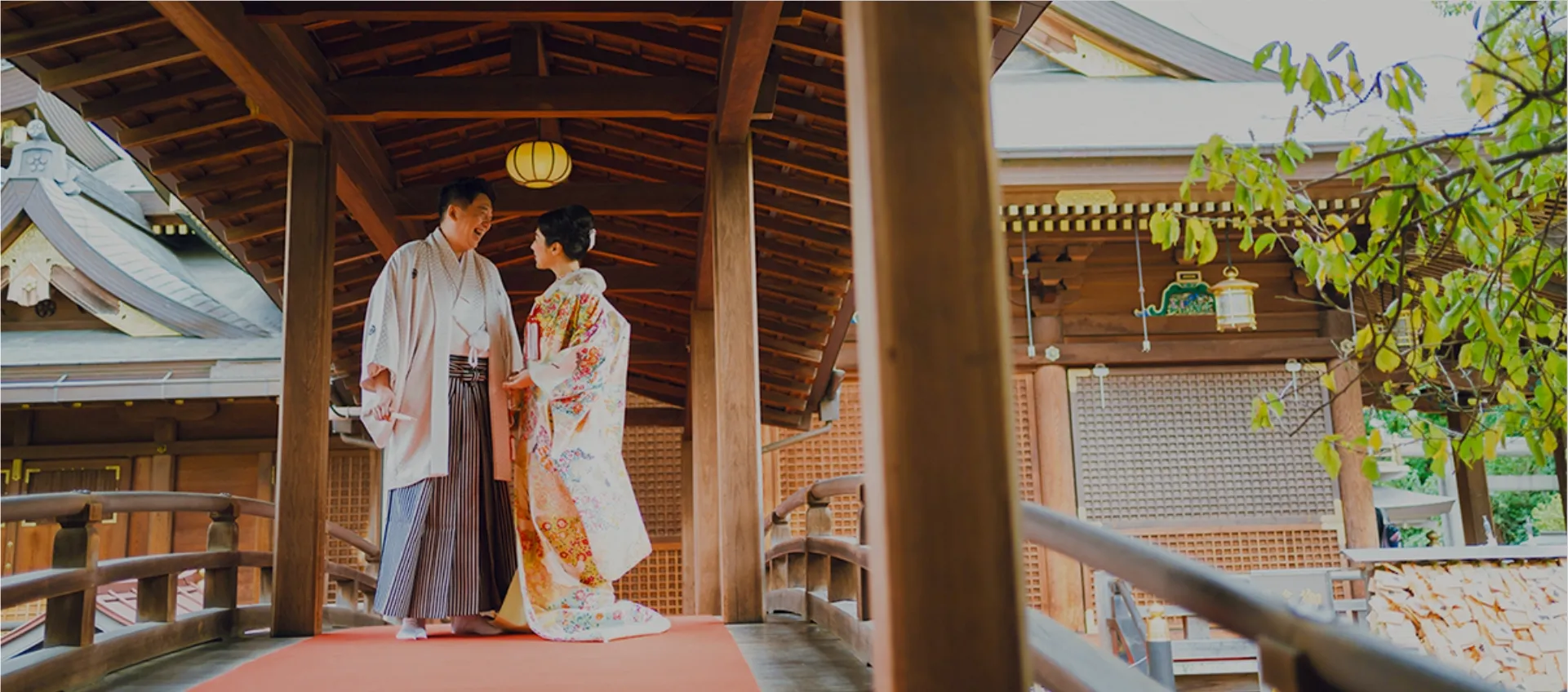 湯島天満宮の太鼓橋で白袴の新郎と着物姿の新婦が見合っている。