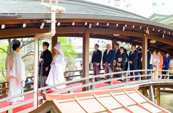 湯島天神の太鼓橋を渡る新郎新婦と一族