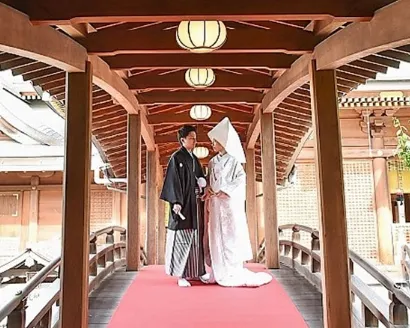 太鼓橋の上で向かい合う袴姿の新郎と白無垢の花嫁